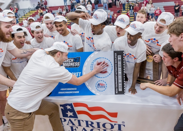 Colgate senior Alex Capitano slaps the Colgate sticker on the March Madness ticket.